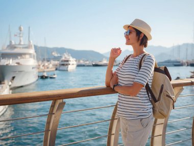 Marmaris, Türk Rivierası 'nın Turkuaz Sahili' ndeki tatil beldesi. Marmaris denize açılmak ve dalmak için harika bir yer. İskelede yürüyen şapkalı Asyalı kadın..