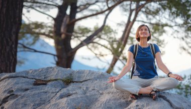 Türkiye 'de Antalya yakınlarındaki Lycian Yolu' nda yürüyen bir kadın gezgin. Gündoğumu dağlarında meditasyon yapan bir kadın. Seyahat için ruhsal rahatlama kavramı. Doğayla uyum..