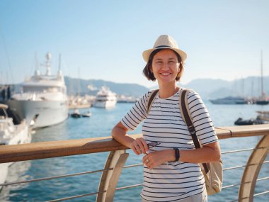 Marmaris, Türk Rivierası 'nın Turkuaz Sahili' ndeki tatil beldesi. Marmaris denize açılmak ve dalmak için harika bir yer. İskelede yürüyen şapkalı Asyalı kadın..
