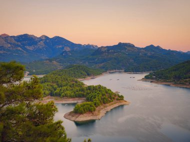 Burdur bölgesindeki hindiyi dolaş. Türkiye 'de gün batımında Karacaoren gölü ve dağlar hava manzarası görülüyor. Turkuaz su manzaralı orman adası. Vahşi doğa çok güzel yerlere gidiyor.