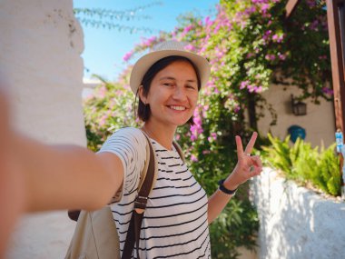 Marmaris, Turkuaz Sahili olarak bilinen Türk Rivierası 'ndaki tatil köyüdür. Marmaris denize açılmak ve dalmak için harika bir yer. Marmaris 'in güzel sokaklarındaki turist kadın akıllı telefondan selfie çekiyor..