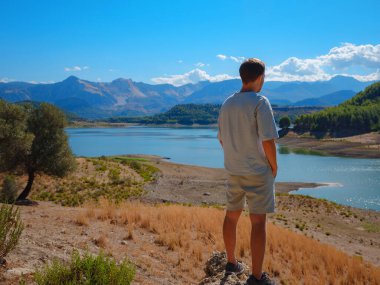 Turistler Karacaoren Gölü 'ne, dağlara, dağlara, Akdeniz manzarasına ve sıcak yaz günü St. Peter Yolu' na bakarlar. Sıfır atık yolculuğu, aktif yaşam tarzı, yaz tatili
