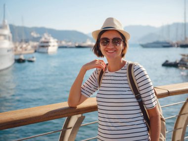 Marmaris, Türk Rivierası 'nın Turkuaz Sahili' ndeki tatil beldesi. Marmaris denize açılmak ve dalmak için harika bir yer. İskelede yürüyen şapkalı Asyalı kadın..