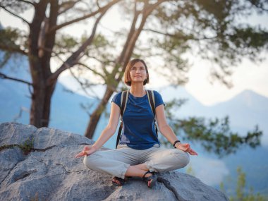 Türkiye 'de Antalya yakınlarındaki Lycian Yolu' nda yürüyen bir kadın gezgin. Gündoğumu dağlarında meditasyon yapan bir kadın. Seyahat için ruhsal rahatlama kavramı. Doğayla uyum..