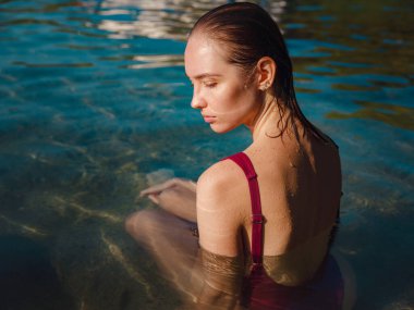 Kemer Antalya ilinin Phaselis kenti yakınlarındaki plajda dinlenen mayo giyen bayan turist. Eski Roma hamamlarının, tiyatroların, su kemerlerinin kalıntıları ve plajları olan antik bir liman şehri.