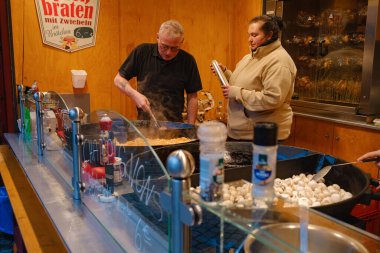 Düsselldorf, Almanya - 13 Aralık 2022: Noel pazarında farklı noel hediyeleri. Festivalde yemek hazırlığı