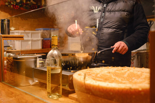 Дюссельлдорф, Германия - 13 декабря 2022 года: различные виды рождественских лакомств на Рождественском рынке. приготовление пищи на фестивале