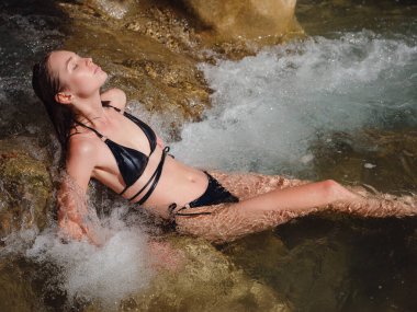 Sıcak bir yaz gününde Türkiye seyahati, Akdeniz bölgesi. Mayolu genç bir kadın dağ nehrinde eğleniyor. Açık hava, seyahat, aktif yaşam tarzı, yaz tatili, Friluftsliv