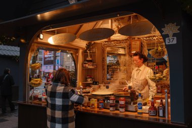 Köln, Almanya - 13 Aralık 2022: Noel pazarında farklı noel hediyeleri. Festivalde yemek hazırlığı