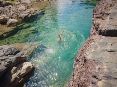 Sıcak bir yaz gününde Türkiye seyahati, Akdeniz bölgesi. Mayolu genç bir kadın dağ nehrinde eğleniyor. Açık hava, seyahat, aktif yaşam tarzı, yaz tatili kavramı.