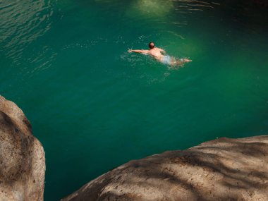 Sıcak bir yaz gününde Türkiye seyahati, Akdeniz bölgesi. Mayolu genç bir kadın dağ nehrinde eğleniyor. Açık hava, seyahat, aktif yaşam tarzı, yaz tatili kavramı.