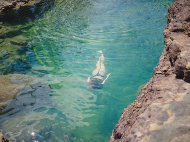 Sıcak bir yaz gününde Türkiye seyahati, Akdeniz bölgesi. Mayolu genç bir kadın dağ nehrinde eğleniyor. Açık hava, seyahat, aktif yaşam tarzı, yaz tatili kavramı.