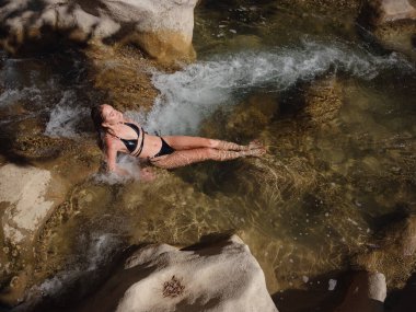 Sıcak bir yaz gününde Türkiye seyahati, Akdeniz bölgesi. Mayolu genç bir kadın dağ nehrinde eğleniyor. Açık hava, seyahat, aktif yaşam tarzı, yaz tatili, Friluftsliv