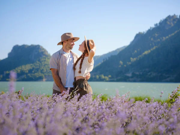 concept of embracing fresh air and engaging in outdoor activities. Couple of hipster Enjoy moment of happiness and love in lavender field in mountains. Love in lavender concept.