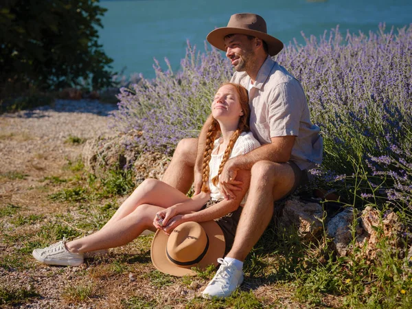 concept of embracing fresh air and engaging in outdoor activities. Couple of hipster Enjoy moment of happiness and love in lavender field in mountains. Love in lavender concept.
