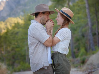 Temiz havayı kucaklama ve açık hava aktiviteleriyle meşgul olma kavramı. Doğada birbirine sarılıp gülümseyen sevgi dolu genç bir çift. Türkiye 'de Dağlar Ormanı Yürüyüşü
