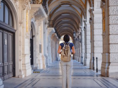 summer female solo trip to Europe, happy young woman walking on european street of Vienna, Austria