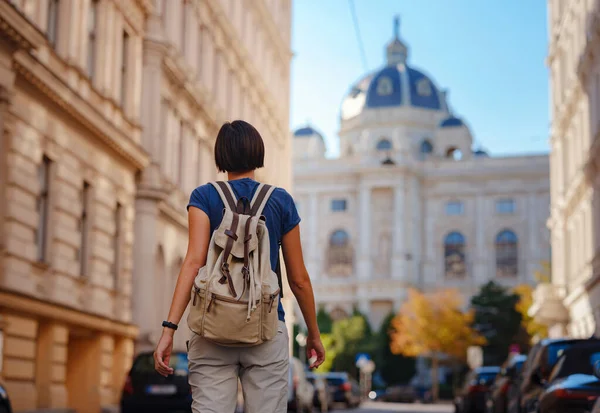 summer female solo trip to Europe, happy young woman walking on european street of Vienna, Austria