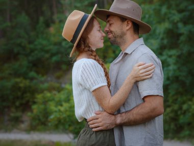 Temiz havayı kucaklama ve açık hava aktiviteleriyle meşgul olma kavramı. Doğada birbirine sarılıp gülümseyen sevgi dolu genç bir çift. Türkiye 'de Dağlar Ormanı Yürüyüşü