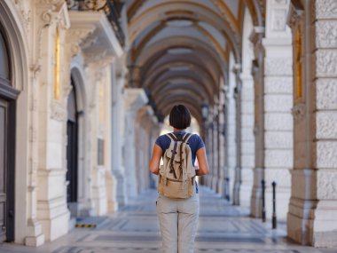 summer female solo trip to Europe, happy young woman walking on european street of Vienna, Austria