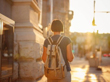 summer female solo trip to Europe, happy young woman walking on european street at sunset time. Vienna, Austria