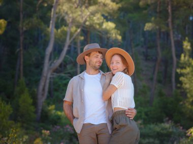 Temiz havayı kucaklama ve açık hava aktiviteleriyle meşgul olma kavramı. Doğada birbirine sarılıp gülümseyen sevgi dolu genç bir çift. Türkiye 'de Dağlar Ormanı Yürüyüşü