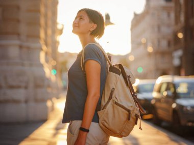 summer female solo trip to Europe, happy young woman walking on european street at sunset time. Vienna, Austria