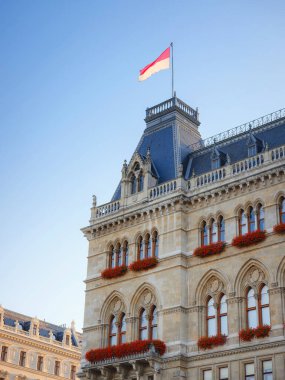 Scenic view of Viena capital, impressive gothic architecture of City hall or Rathaus . Travel and landmarks of Austria, details and flowers and flag of Vienna on buildings