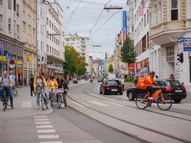 Linz, Austria - August 6, 2022 : View through the main street of the city with walking people, shops, and tram lines. Linz is the third-largest city of Austria