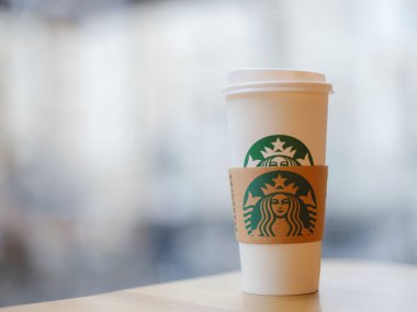 Vienna, Austria - August 8, 2022: Close up Starbuck hot coffee cup with blur Starbuck interior for background.