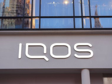 Munich, Germany - August 4, 2022: Facades IQOS store in city. IQOS advertisement. Heating tobacco system iqos tobacco product technologies beloning to Philip Morris International