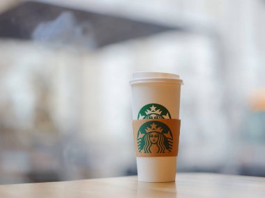 Vienna, Austria - August 8, 2022: Close up Starbuck hot coffee cup with blur Starbuck interior for background.