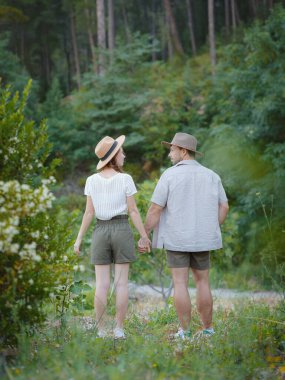 Temiz havayı kucaklama ve açık hava aktiviteleriyle meşgul olma kavramı. Doğada birbirine sarılıp gülümseyen sevgi dolu genç bir çift. Türkiye 'de Dağlar Ormanı Yürüyüşü
