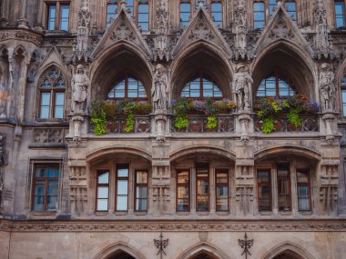 Facade of Neo-Gothic town hall with daily performances to the sound of bells and a tall tower overlooking the city in Marienplatz Munich