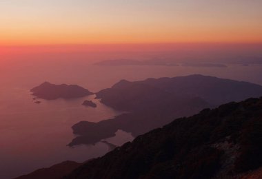 Oludeniz 'de beyaz kumlu Mavi Göl manzarası. Yaz denizi ve tepedeki dağdan güzel bir manzara. Gün batımı zamanı