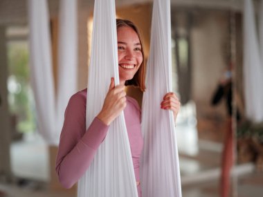workshop of air yoga and stretching in yoga studio. woman before class of antigravity yoga with hammock. balance between mental and physical, one person effort and achievement concept