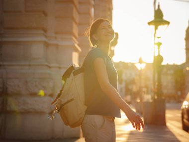 summer female solo trip to Europe, happy young woman walking on european street at sunset time. Vienna, Austria