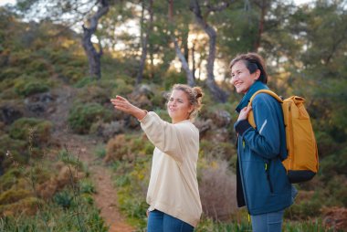 İki kadın Fethiye 'de gün batımının keyfini çıkarıyor. Birlik, akıl sağlığı, ekolojik seyahat. Dağlarda yürüyüş, seyahat, güzel anlar, dijital detoks.