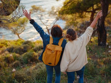 İki kadın Fethiye 'de gün batımının keyfini çıkarıyor. Birlik, akıl sağlığı, ekolojik seyahat. Dağlarda yürüyüş, sarılma, seyahat, güzel anlar, dijital detoks.