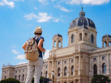 summer female solo trip to Europe, happy young woman walking on european street. Maria Theresa square near museum of Natural history in Vienna.