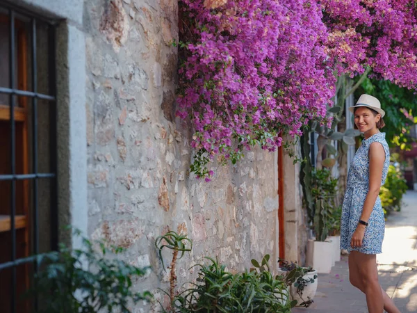 Stock image Blooming bougainvillea, streets of the old town of Bodrum, Turkey. Happy traveler woman in white elegant outfit walking by romantic streets . Summer travelling