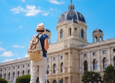 summer female solo trip to Europe, happy young woman walking on european street. Maria Theresa square near museum of Natural history in Vienna.