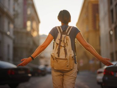 summer female solo trip to Europe, happy young woman walking on european street at sunset time. Vienna, Austria