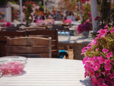 Bodrum 'dan Türkiye' ye yaz yolculuğu. Bodrum, Gumusluk Town 'daki Ege balık lokantası masası. Restoran masaları ve sandalyeler denizde.