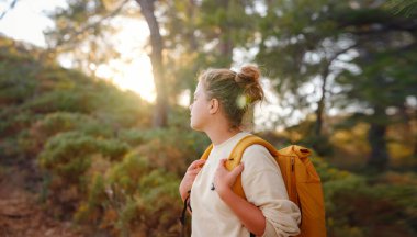 Seyahat ve aktif yaşam tarzı konsepti. Dağlarda yürüyüş yapan mutlu kadın, Fethie, Türkiye. Genç bayan yürüyüşçü güler, spor yapar ve sonbaharda veya ilkbaharda yürüyüşe çıkar..