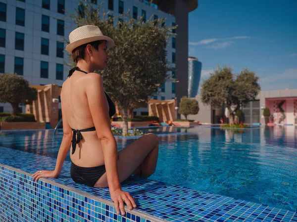 穿着黑色泳衣 头戴帽子 在游泳池温泉放松的美丽的亚洲女人的画像 炎炎夏日 阳光灿烂 旅游中的健康身体护理 — 图库照片