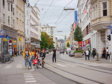 Linz, Austria - August 6, 2022 : View through the main street of the city with walking people, shops, and tram lines. Linz is the third-largest city of Austria