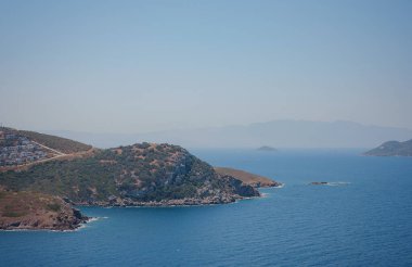 Bodrum 'dan Türkiye' ye yaz yolculuğu. Yaz öğlen deniz köyü Gumusluk Mugla ili, açık mavi suyla körfez