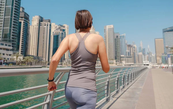 Stock image City Running - asian woman runner , Dubai marina urban scene in background. Female athlete, fitness athlete jogging training, living healthy lifestyle. back view