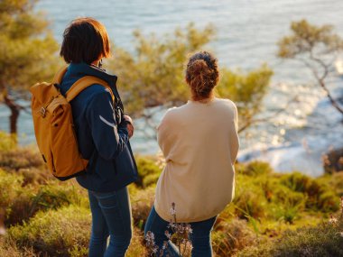 İki kadın Fethiye 'de gün batımının keyfini çıkarıyor. Birlik, akıl sağlığı, ekolojik seyahat. Dağlarda yürüyüş, seyahat, güzel anlar, dijital detoks.